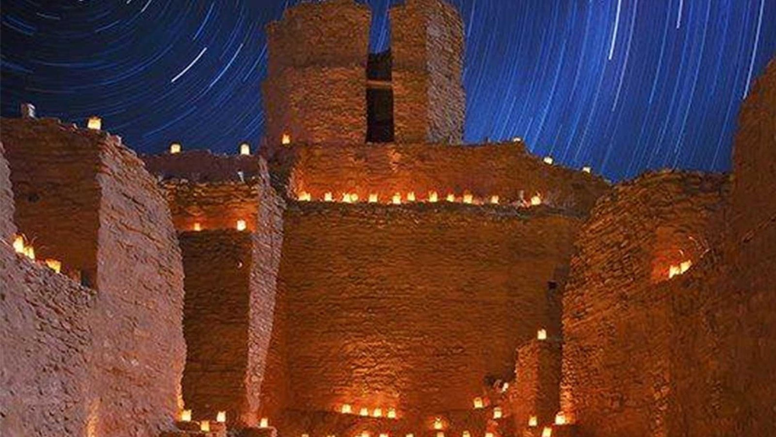 Adobe building with lanterns and night sky